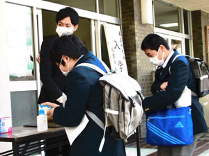 検温・手を消毒して入場する生徒の写真