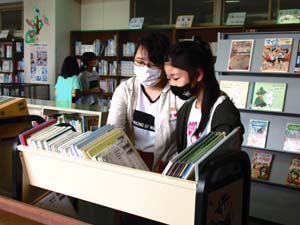 借りたい本を選ぶ女子児童二人の写真