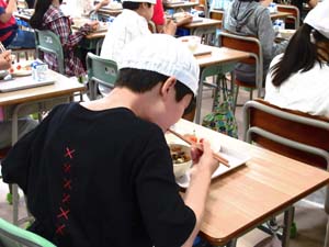 給食を食べる男子児童の写真